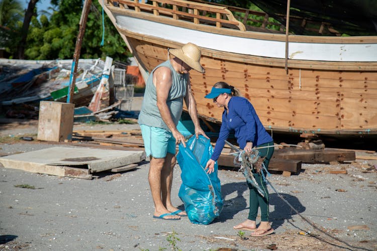 Man And A Woman Cleaning A Beach