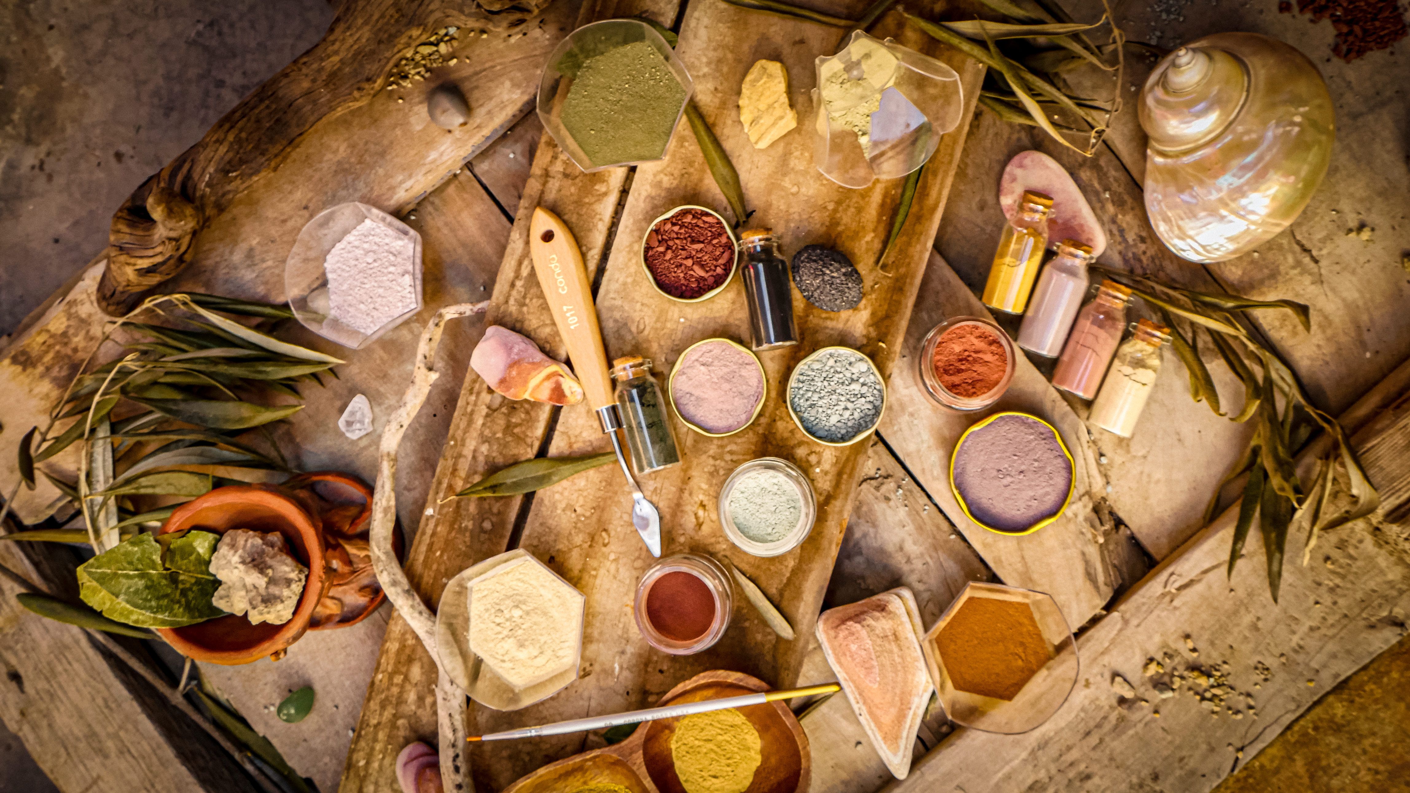 Colored mineral powders in bowls and glass bottles