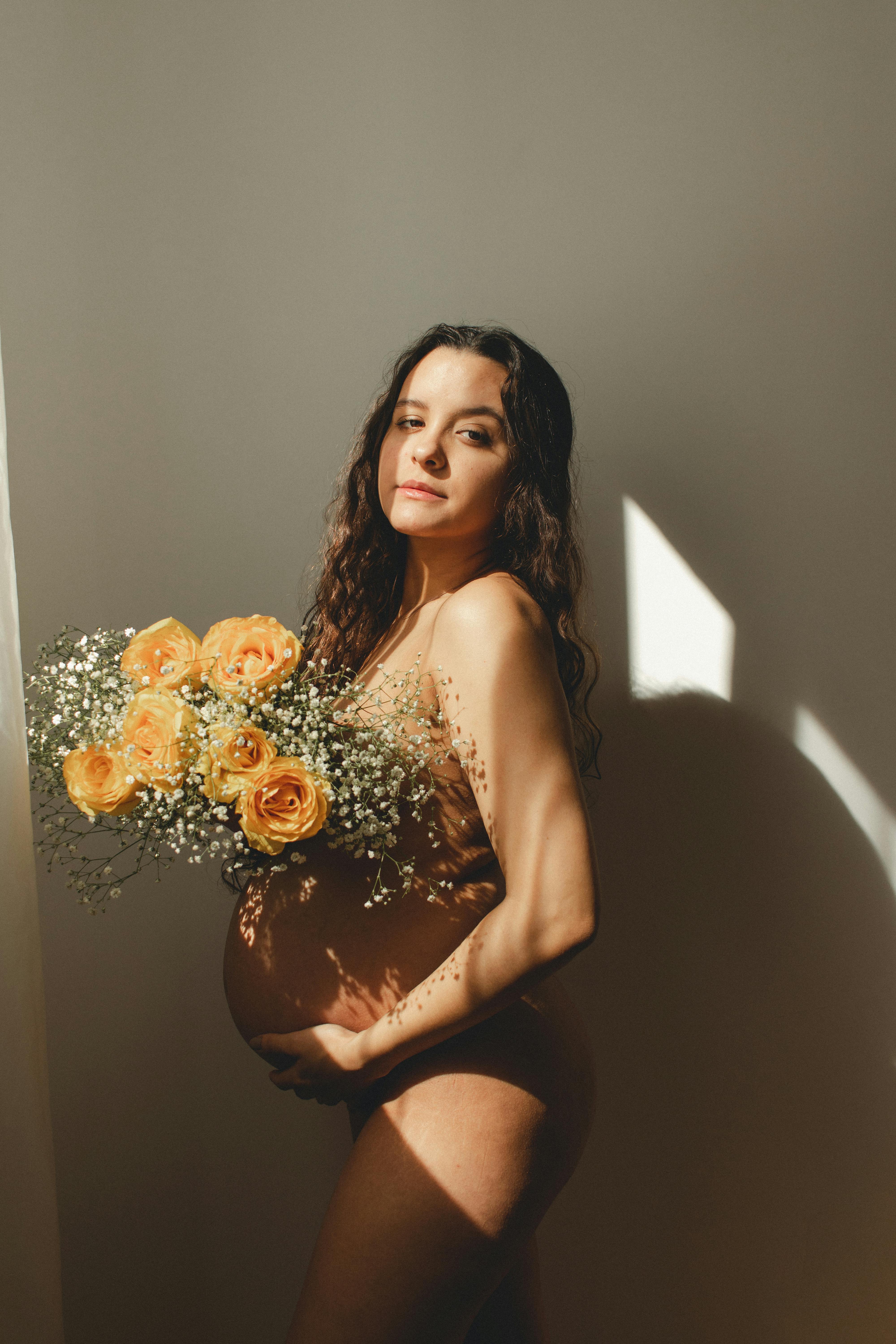 a pregnant woman holding flowers