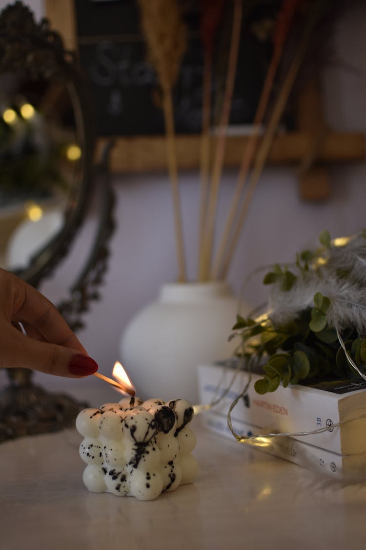 A Person Lighting A Candle 