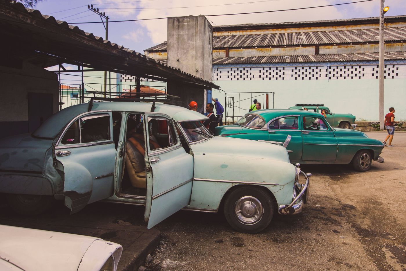Several vintage automobiles parked along a street
