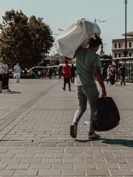 Man in Green T-shirt and Gray Pants Walking on Sidewalk