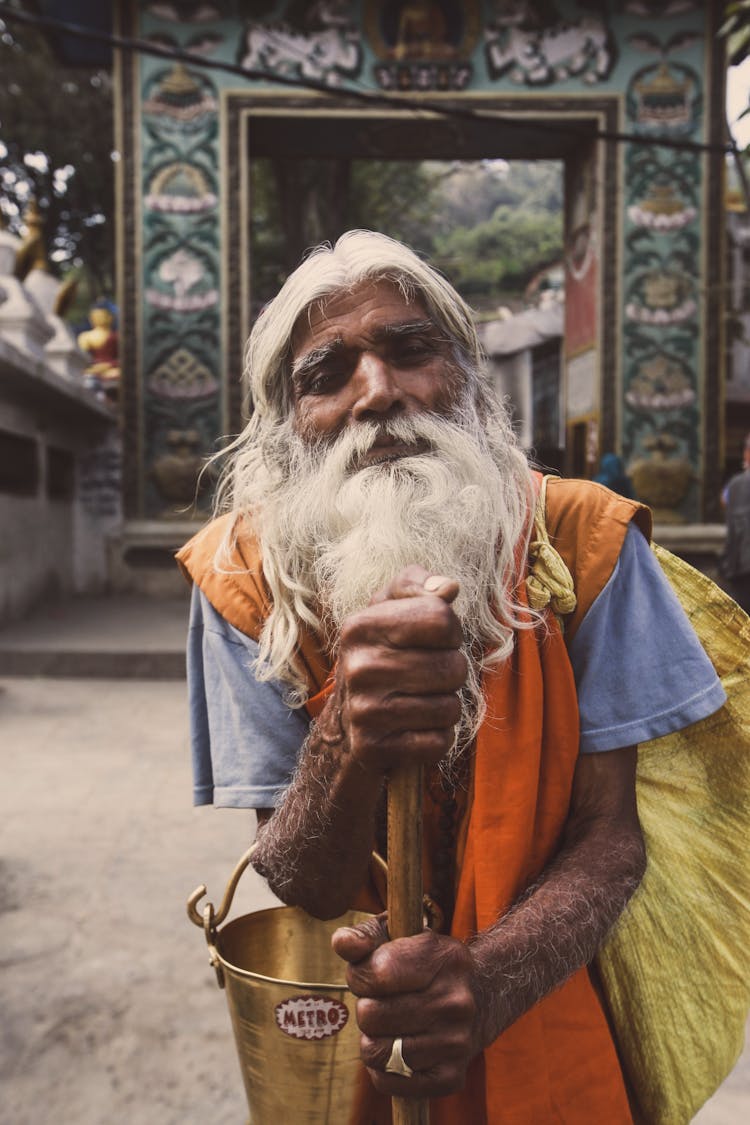 Elderly Man Holding Wooden Stick