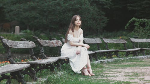 A Woman in White Dress Sitting on a Bench