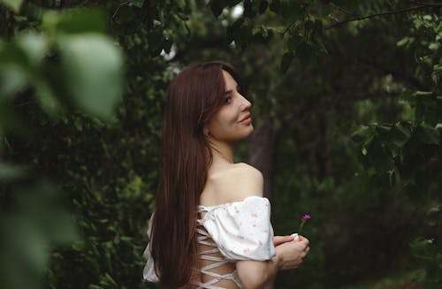 Woman Wearing an Off Shoulder Blouse Holding Pink Flower