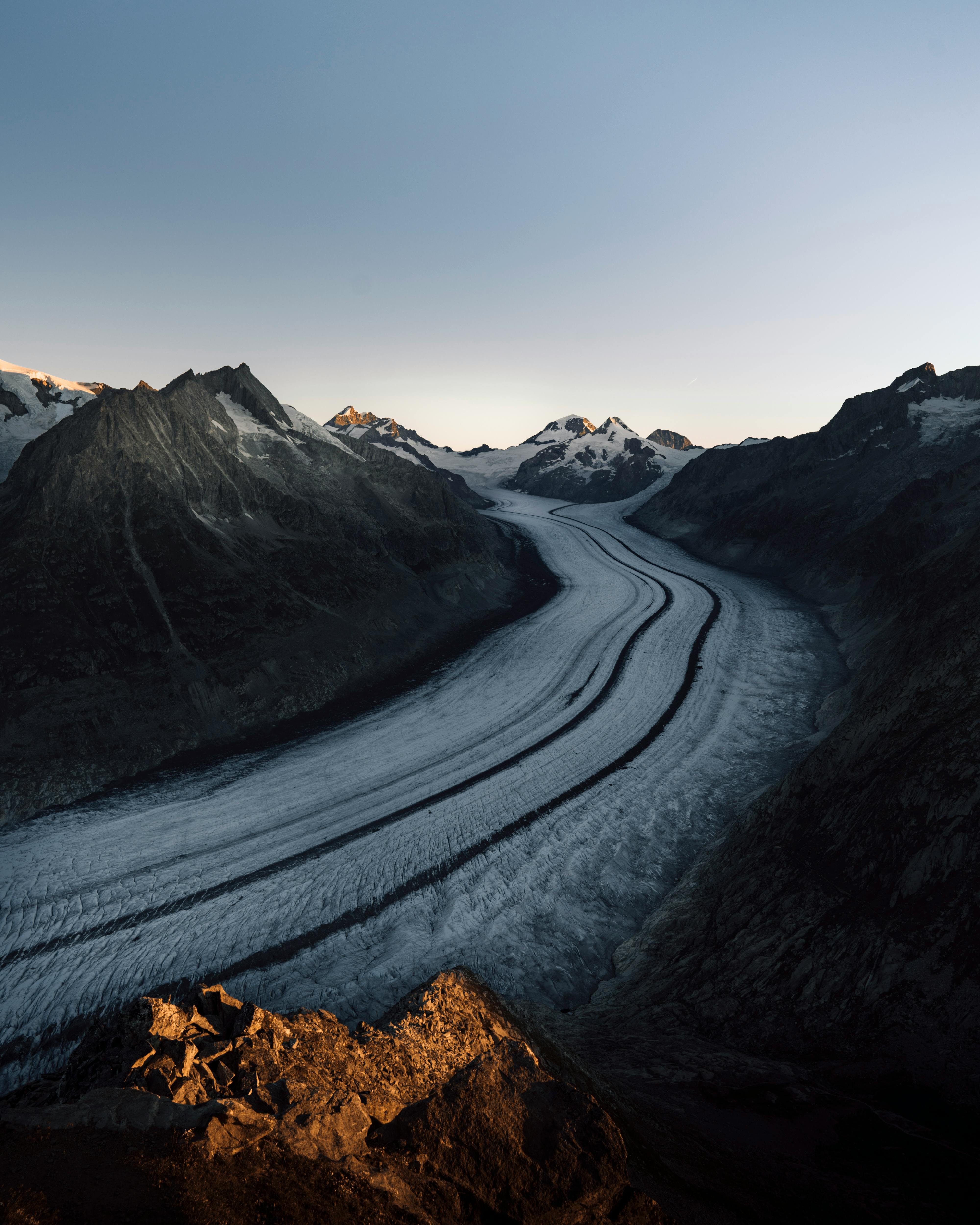 Stunning sunrise over the Aletsch Glacier in Fieschertal, Switzerland, showcasing ice formations and mountain peaks.