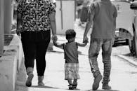 在多米尼加共和国圣地亚哥，一个阳光明媚的日子里，一家三口手牵着手散步