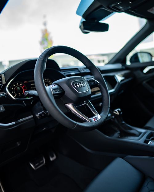 Free Sleek and modern Audi car interior showcasing a leather steering wheel, perfect for luxury automotive enthusiasts. Stock Photo