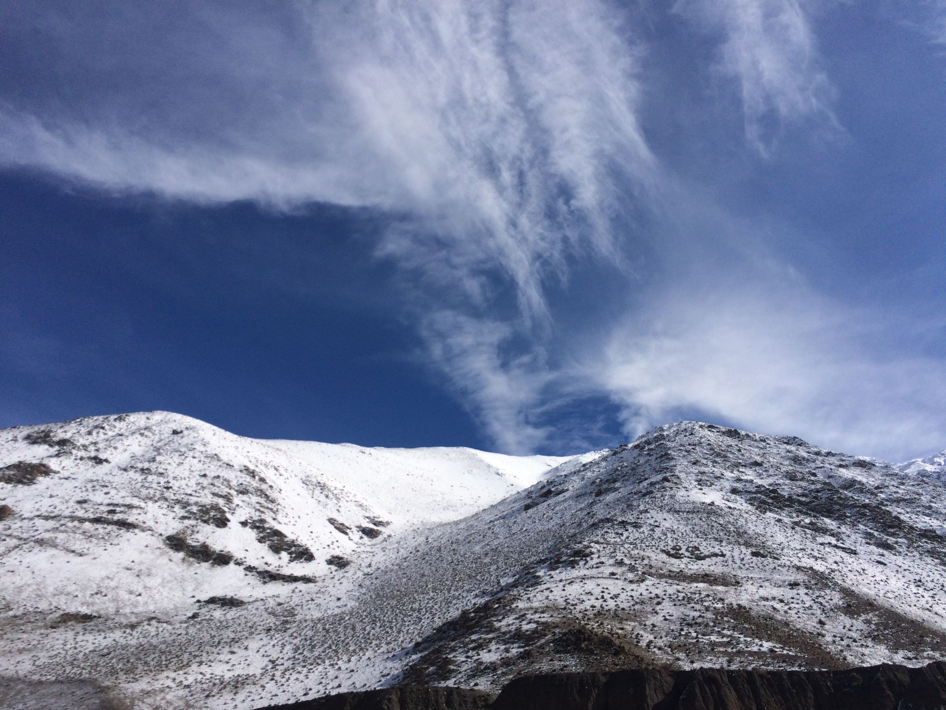 Beautiful snow-covered mountains in Muytha, Bolivia, under a clear blue sky and wispy clouds. - Potosí