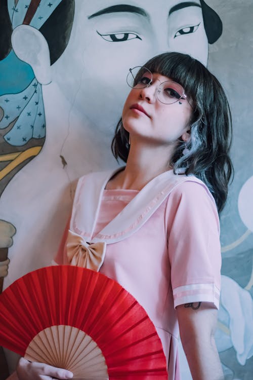 Woman in Pink Dress Holding Red Fan