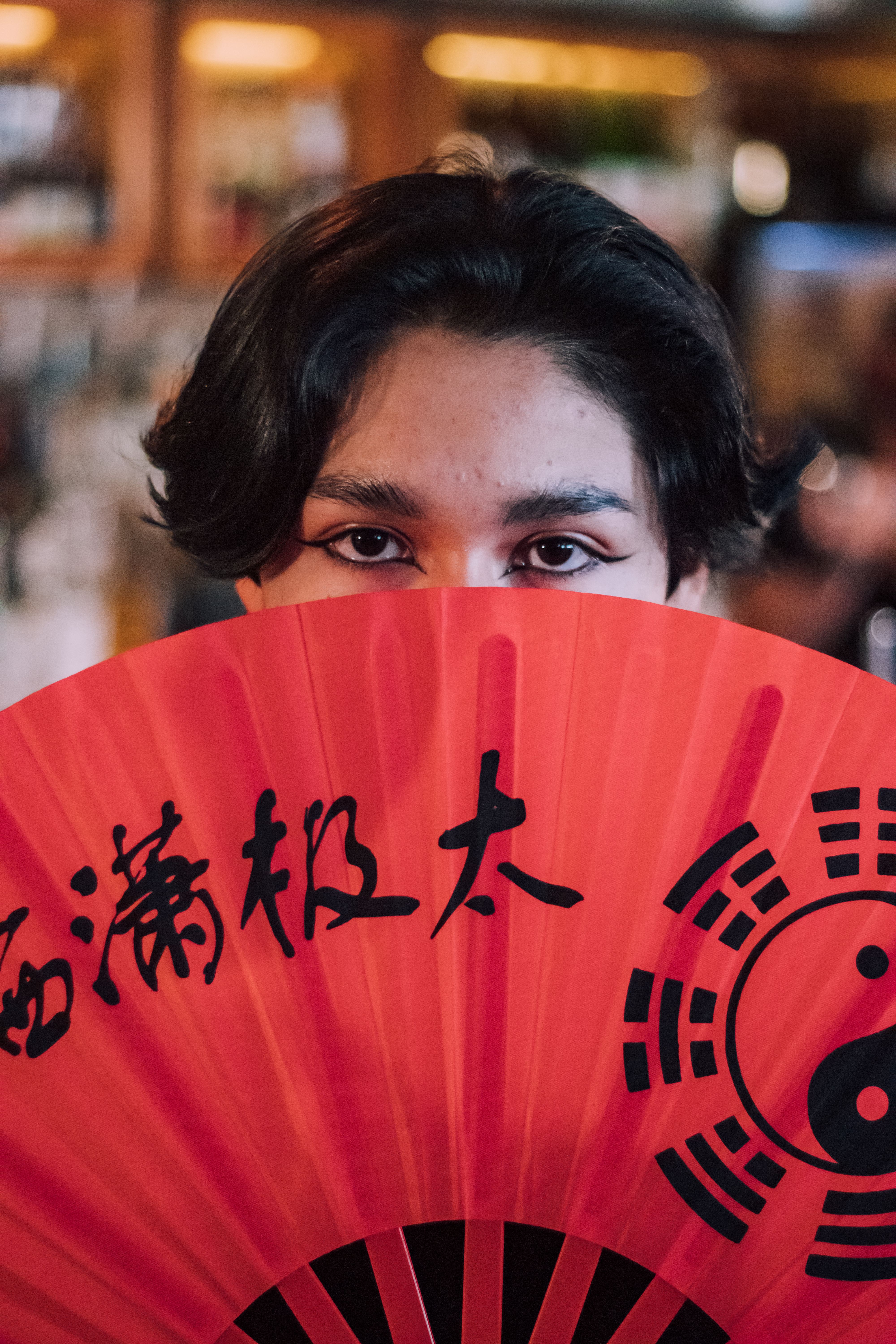 Person Hidden Behind a Red Paper Fan · Free Stock Photo