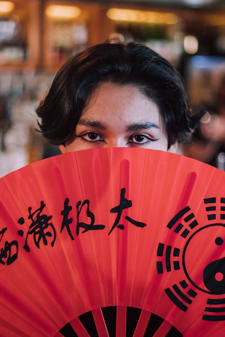 Person Hidden Behind A Red Paper Fan