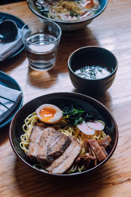 Appetizing Japanese ramen with pork belly, egg, and vegetables served in a cozy restaurant.