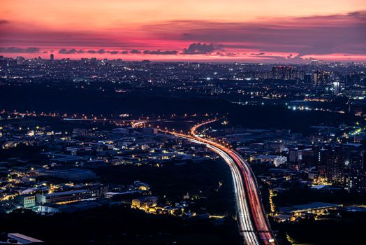 Capture of Sanxia District's vibrant cityscape at twilight with colorful sky and light trails.