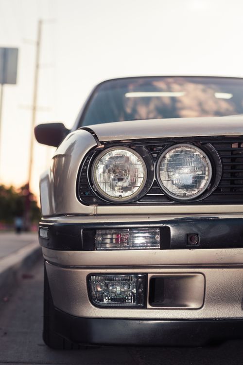 Free Detailed close-up of a vintage car's front with headlights, showcasing timeless design. Stock Photo