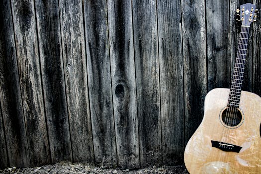 An acoustic guitar resting against a textured wooden wall, evoking a rustic musical charm.