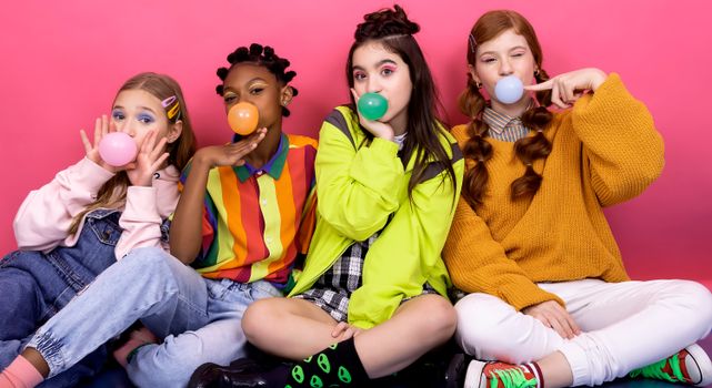 Teen Girls Blowing Gum Bubbles on Pink Background