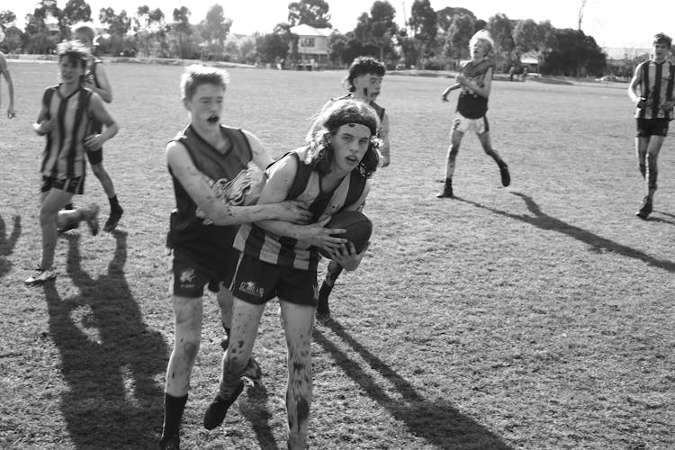 Grayscale Photo Of People Playing Football