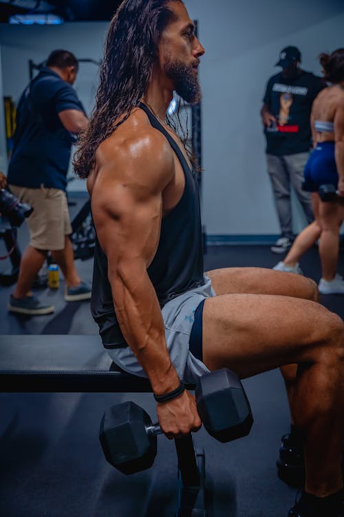 Man in a Black Tank Top Holding a Dumbbell