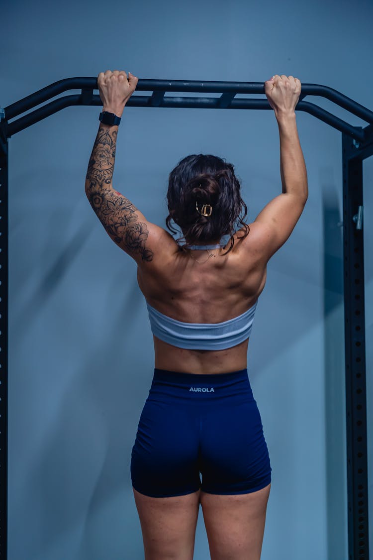 A Woman Holding On Pull Up Bar