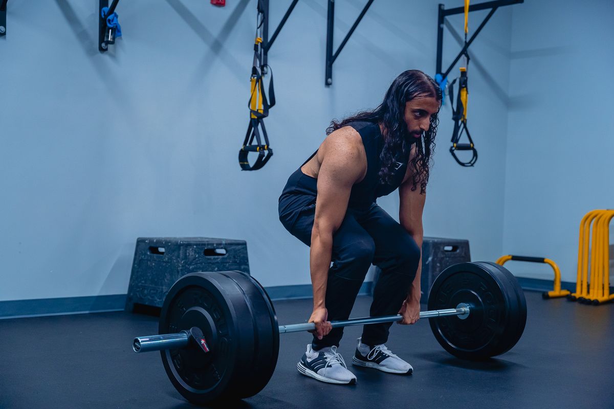 Man performing deadlifts in a gym with controlled form