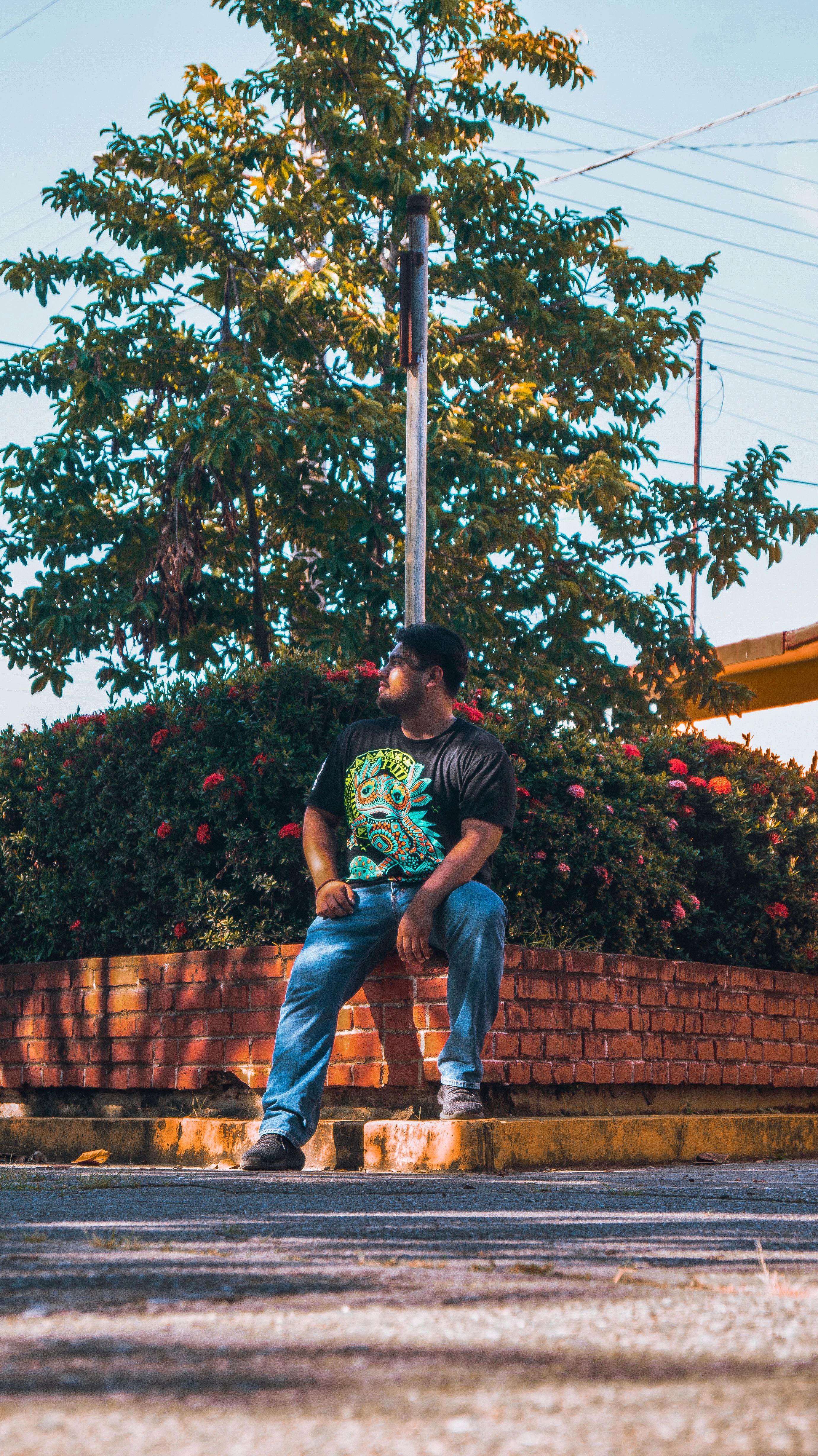 Casual portrait of a man sitting by a flowerbed in San Juan Bautista Tuxtepec, Mexico during daytime.
