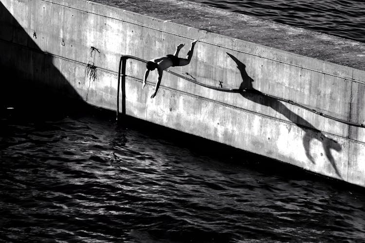 Grayscale Photo Of A Person Diving On The River