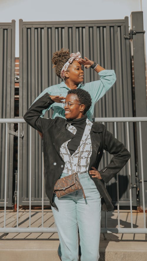 Women Standing Near Metal Fence while Looking Afar