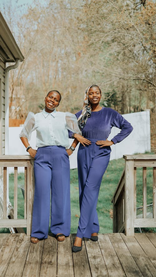 Women Leaning on a Wooden Railings while Posing at the Camera