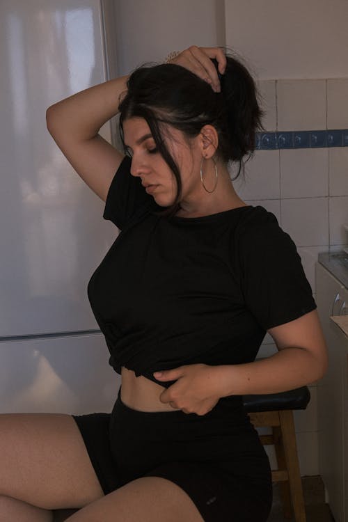 Foto d'estoc gratuïta de assegut, camisa negra, dona