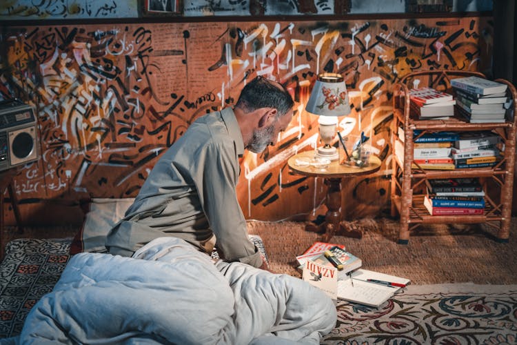 Elderly Man In Bedroom With Books