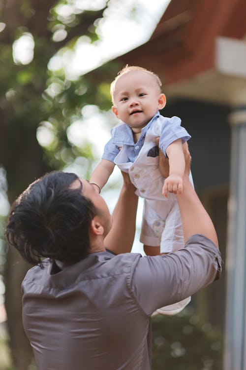 A Man Lifting a Toddler