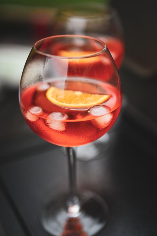 Free A close-up view of a vibrant cocktail with orange slice and ice cubes, perfect for a refreshing summer drink. Stock Photo