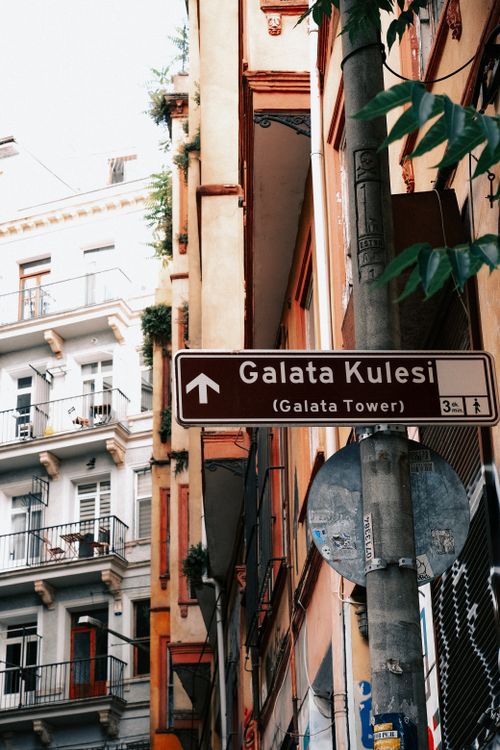 Free Urban street scene featuring a directional sign for Galata Tower in Istanbul. Stock Photo