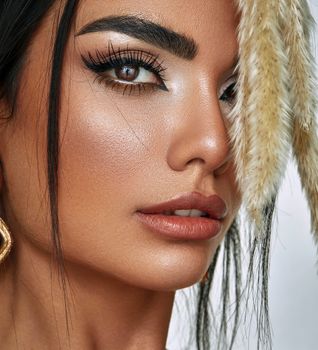 Elegant close-up portrait of a woman highlighting her makeup and striking features.