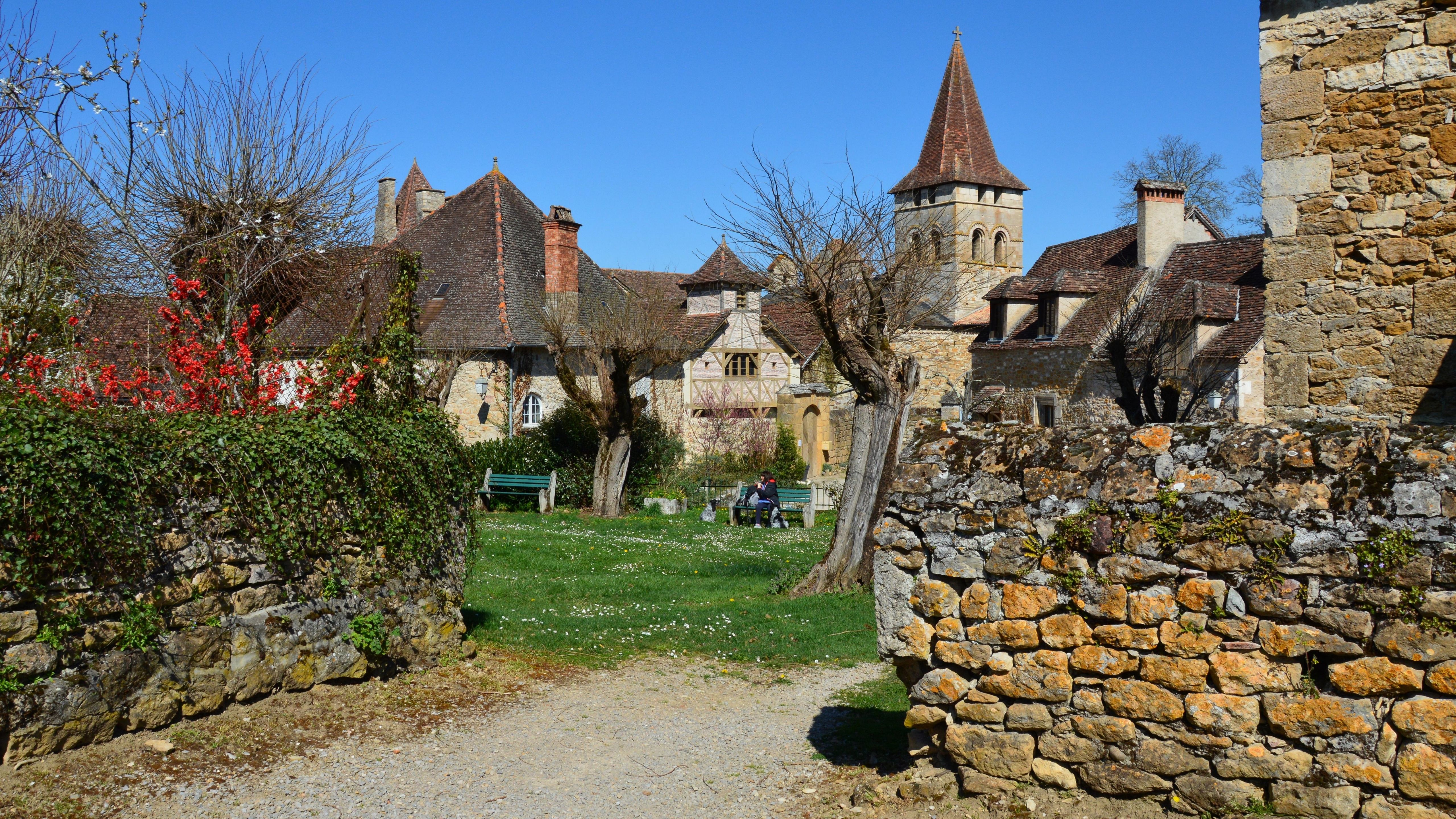 Beautiful view of a medieval village in Carennac, France with stone buildings and blue sky.