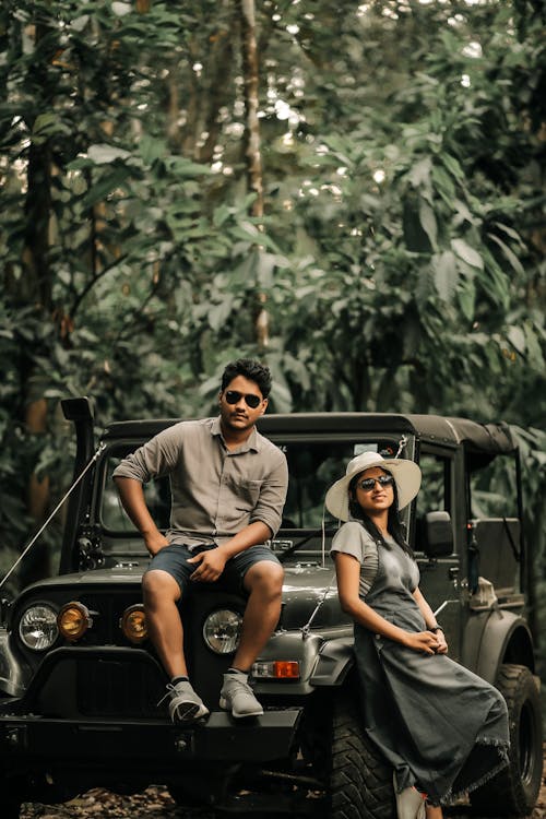 A Couple Sitting on Black Jeep