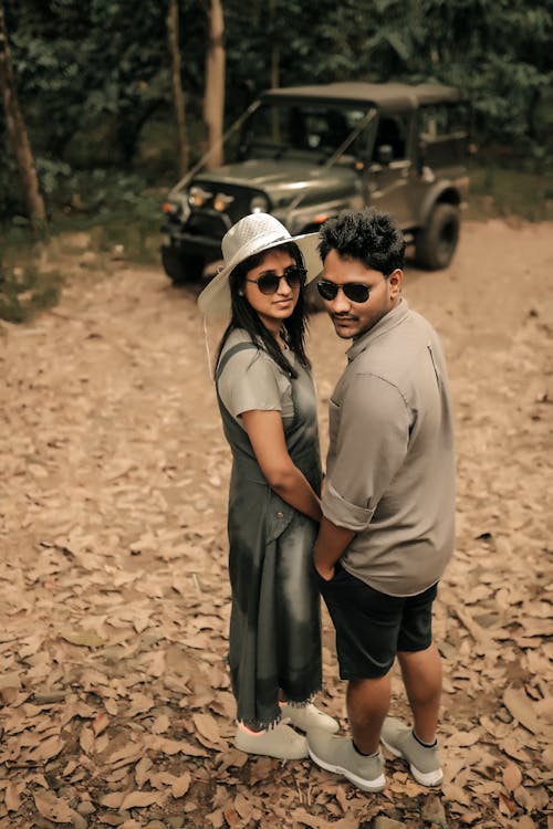 A Man and Woman Standing on Brown Dried Leaves