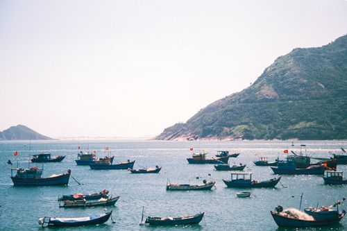 Free Discover the serene beauty of fishing boats floating in the tranquil waters of Khánh Hòa, Vietnam. Stock Photo