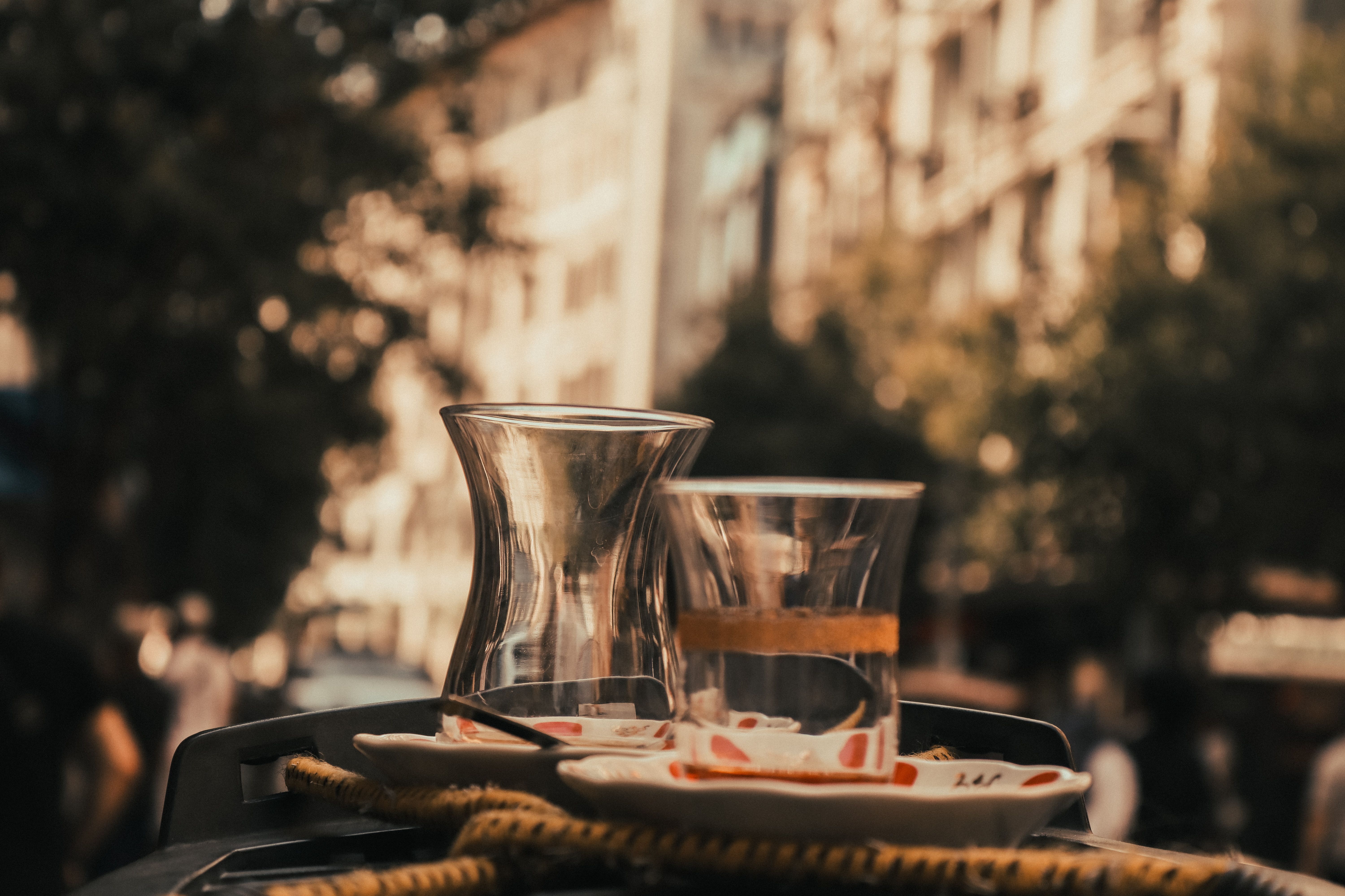 Elegant tea being poured from teapot into glass cup, with reflection.