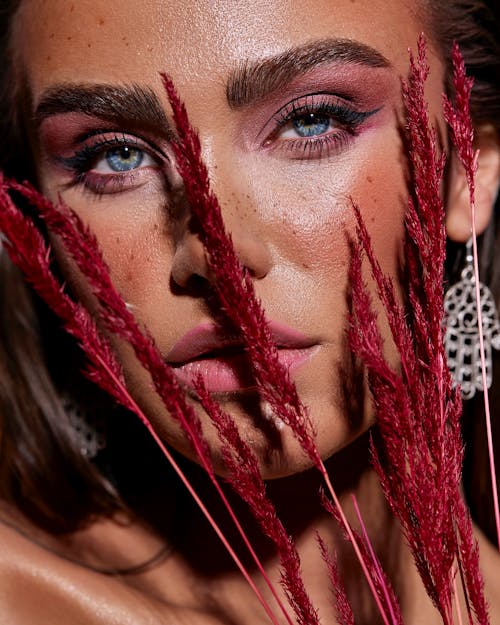 Close-Up Shot of a Pretty Woman Holding Red Dry Flowers