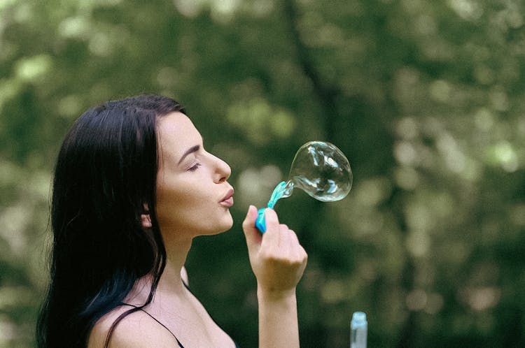 Beautiful Woman Blowing A Bubble