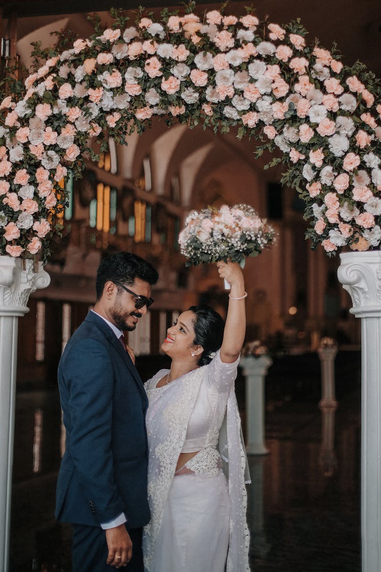 Wedding Couple Under A Flower Arch