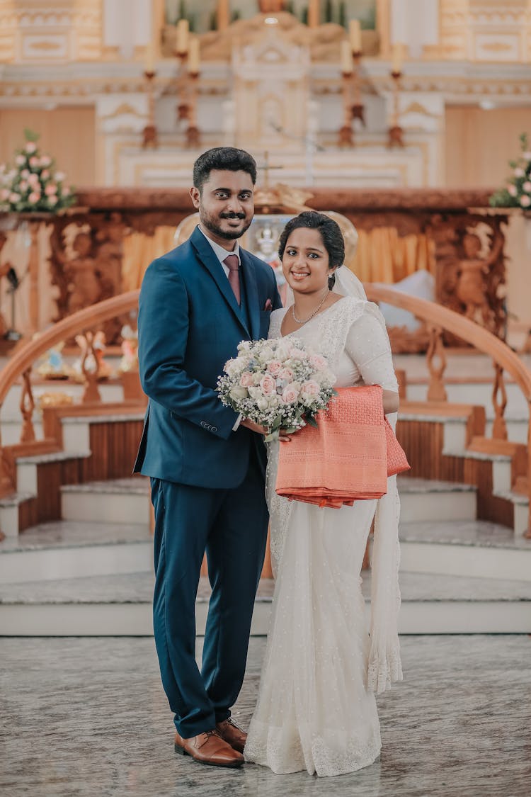 A Bride And Groom Standing At The Front Of The Altar