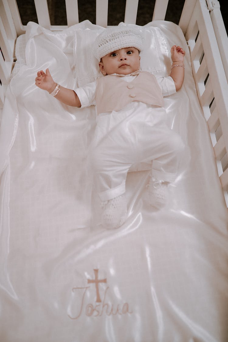 Newborn Boy Lying In A Baby Cot