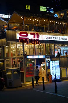 Colorful Korean restaurant facade at night with vibrant lights and lively atmosphere.