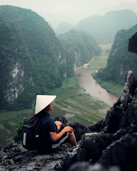 Traveler enjoying the breathtaking view from Ninh Bình's mountains in Vietnam.