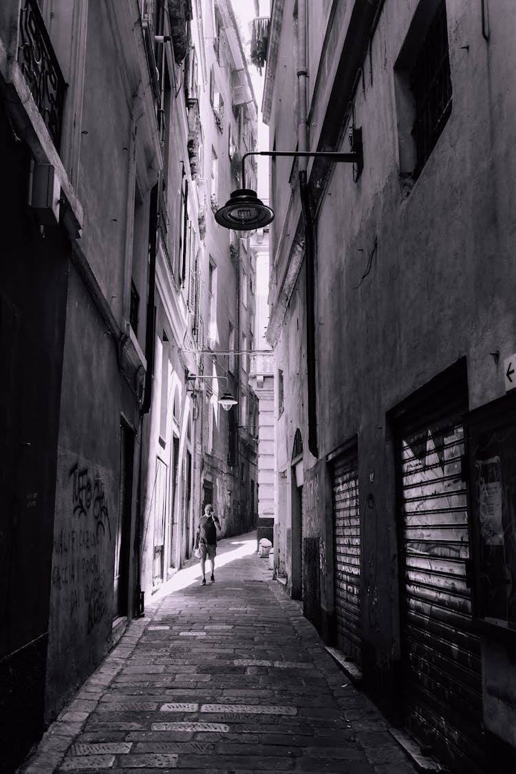 Grayscale Photo Of A Person Walking On The Street