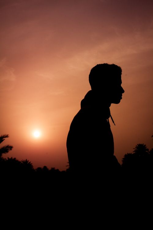 Free Silhouette of a person with a vibrant sunset sky creating a serene atmosphere. Stock Photo