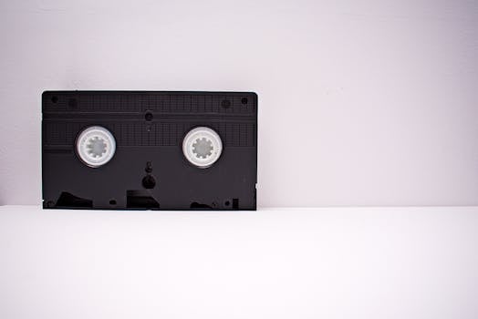 Black VHS tape on a white minimalist background, highlighting retro technology.